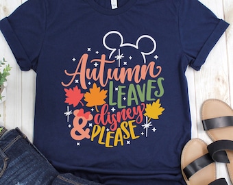 May include: A navy blue t-shirt with the text "Autumn Leaves & Disney Please" in white with a Mickey Mouse silhouette and fall leaves in orange, yellow, and red.