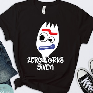 May include: Black t-shirt with a white cartoon character of a fork with a face and the text "zero forks given".