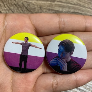 Może przedstawiać: Dwa okrągłe piny z żółtym, białym i fioletowym tłem. Piny przedstawiają osobę z rozłożonymi ramionami i osobę jedzącą kanapkę.