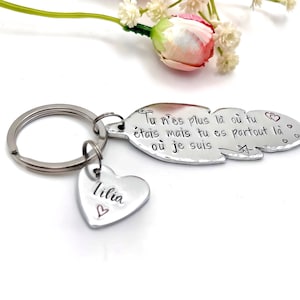 Peut inclure: Un porte-clés argenté avec un charm en forme de cœur gravé du nom "Lilia" et un petit cœur. Le porte-clés comporte également une étiquette en forme de plume avec du texte français et des motifs de cœurs et d'étoiles.