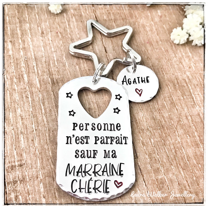 May include: Silver keychain with a star charm and a tag that reads "Personne n'est Parfait sauf ma Marraine Cherie" with a heart. A smaller tag with the name "Agathe" is attached.