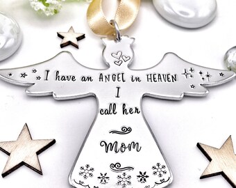 Op de afbeelding: Zilveren engel ornament met de tekst "Ik heb een engel in de hemel die ik mama noem" en sneeuwvlokken rond de onderkant.