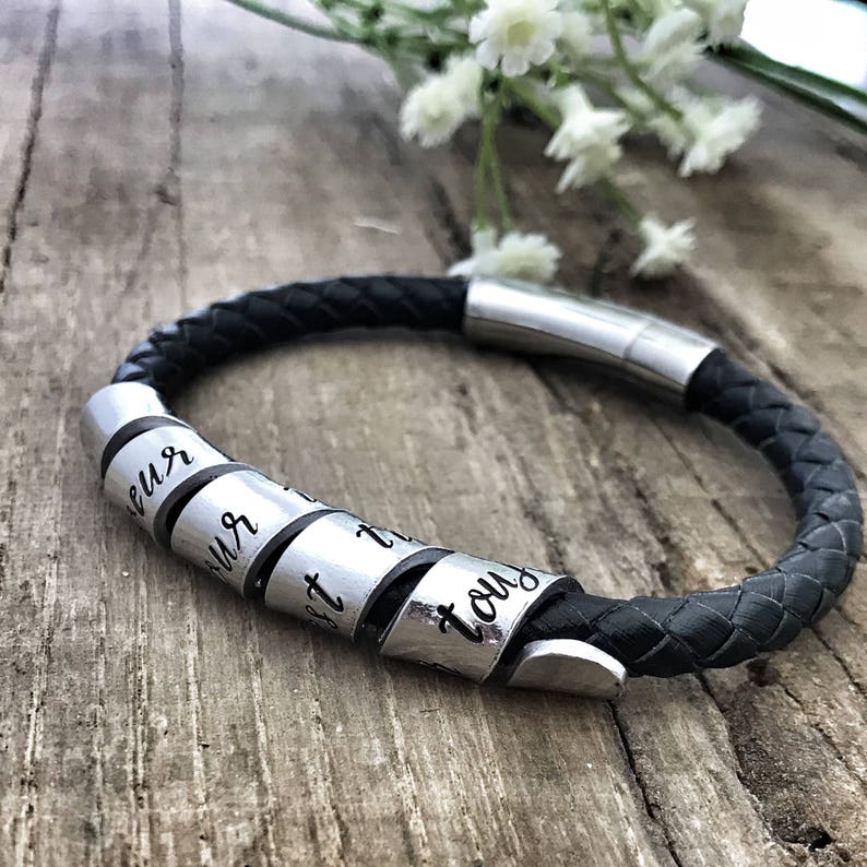 May include: Black leather bracelet with silver metal beads. The beads are engraved with the words "Love", "Your", "Best", "Friend", and "You".
