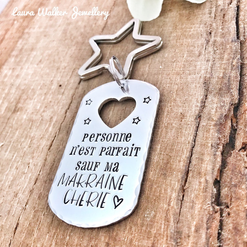 May include: Silver keychain with a star charm and a tag that says "Personne n'est parfait sauf ma Makraine Cherie" with a heart.