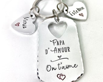 May include: Silver keyring with a heart-shaped tag that says "Papa d'Amour On t'aime" with two smaller heart-shaped tags that say "Marie" and "Esteban".