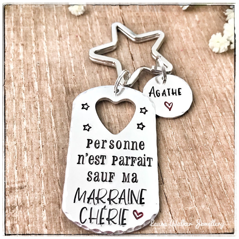May include: Silver keychain with a tag that reads "Personne n'est Parfait sauf ma Marraine Cherie" with a heart and stars. A smaller tag with the name "Agathe" and a heart is attached.