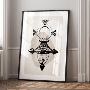 Könnte beinhalten: Schwarz-weiß gerahmter Kunstdruck mit geometrischem Design. Das Kunstwerk hat eine zentrale, symmetrische Form mit kreuzartigen Elementen und einer kreisförmigen Form. Der Hintergrund ist in einem neutralen Beige gehalten, und der Rahmen ist schwarz.