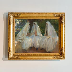 Peut inclure: Peinture à l'huile encadrée dans un cadre doré orné, représentant trois personnages en robes et voiles blancs, assis à l'extérieur. L'œuvre présente un arrière-plan vert luxuriant et des coups de pinceau doux, créant une esthétique classique.