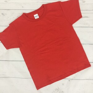 May include: A plain red t-shirt with a Gildan brand tag.