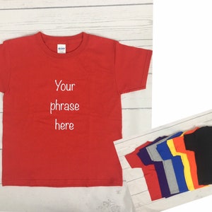 May include: Red, purple, grey, blue, yellow, and orange t-shirts with short sleeves. The red t-shirt has the text "Your phrase here" embroidered on the front.
