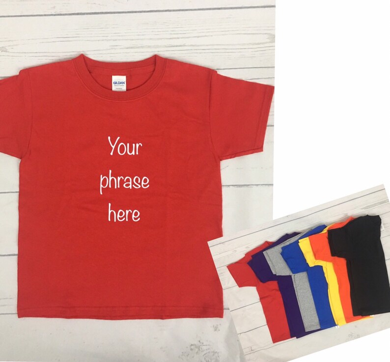 May include: Red, purple, grey, blue, yellow, and orange t-shirts with short sleeves. The red t-shirt has the text "Your phrase here" embroidered on the front.