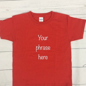 May include: Red short-sleeved t-shirt with white text that says "Your phrase here".