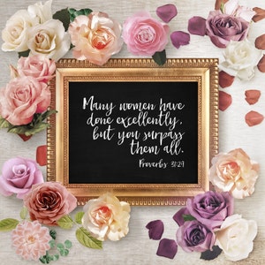 May include: A framed chalkboard with a quote about women, "Many women have done excellently, but you surpass them all. Proverbs 31:29", surrounded by pink, white, and purple roses.