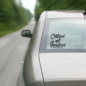 May include: A silver car with a black decal on the back window that reads "Civilized not Socialized #HOMESCHOOLERS".