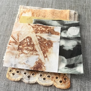May include: A collection of fabric samples in diverse colours and textures. The top swatch displays a leaf print in brown and white tones. Other swatches include beige, yellow, and grey-green shades. A piece of beige lace with scalloped edges is at the bottom.