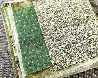 Green fabric snippet bundle: 12 assorted pieces cut from cotton textiles.
