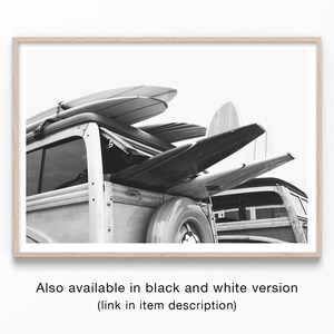 May include: Black and white photograph of a vintage wood-paneled station wagon with surfboards strapped to the roof. The image is framed in a light wood border, evoking a coastal or beach theme. The text at the bottom reads: "Also available in black and white version (link in item description)".