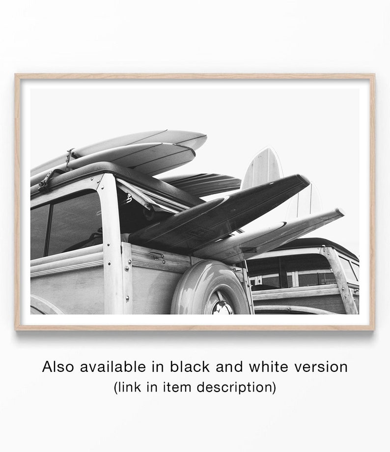 May include: Black and white photograph of a vintage wood-paneled station wagon with surfboards strapped to the roof. The image is framed in a light wood border, evoking a coastal or beach theme. The text at the bottom reads: "Also available in black and white version (link in item description)".