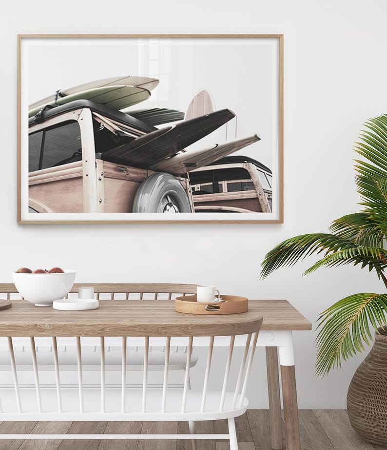 May include: A framed print featuring a vintage wood-paneled station wagon loaded with surfboards. The surfboards are in various colors and designs. The image is set against a white background, evoking a coastal, beachy theme.