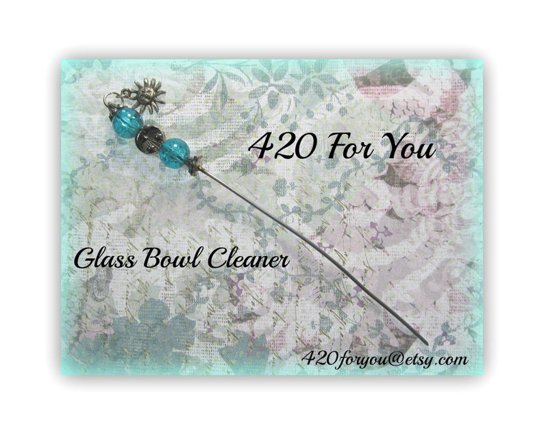 May include: A glass bowl cleaner with a long, thin metal handle and blue glass beads. The handle is decorated with a small, metal sun charm. The text "420 For You" and "Glass Bowl Cleaner" are visible in the image. The text "420foryou@etsy.com" is also visible in the image.