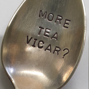 May include: A silver spoon with the words "More Tea Vicar?" engraved on the bowl.