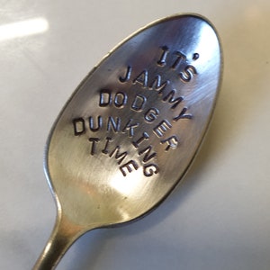 May include: A silver spoon with the words "It's Jammy Dodger Dunking Time" engraved on it.