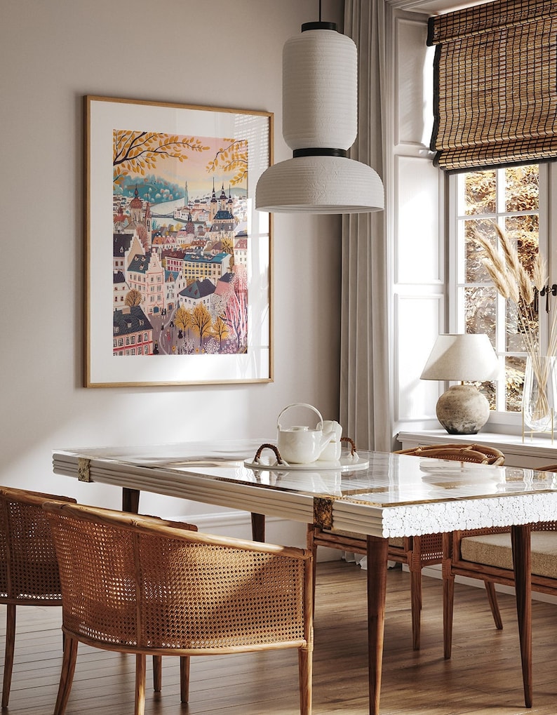 May include: A dining room with a white marble table and four wicker chairs. A white pendant light hangs above the table. A framed print of a city skyline hangs on the wall behind the table.