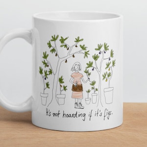 May include: White ceramic mug with a black line drawing of a person standing in front of five potted fig trees. The text "It's not hoarding if it's figs." is printed on the mug.