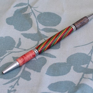 Un stylo à bille bicolore pour étudiant ou enseignant avec un corps tourné à la main en bois laminé, avec des raccords en chrome poli.