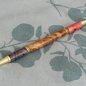 Un stylo à bille bicolore pour étudiant ou enseignant avec un corps tourné à la main en bois d'olivier, avec des raccords en chrome poli.