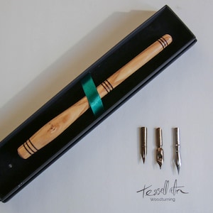 Un stylo à encre de calligraphie (plume) en bois d'olivier tourné à la main