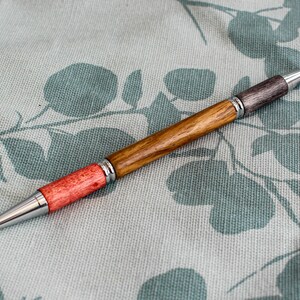 Un stylo à bille bicolore pour étudiant ou enseignant avec un corps tourné à la main en orme anglais, avec des raccords en chrome poli.