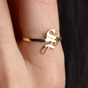 May include: A gold ring with a single initial, the letter "S", in a script font.