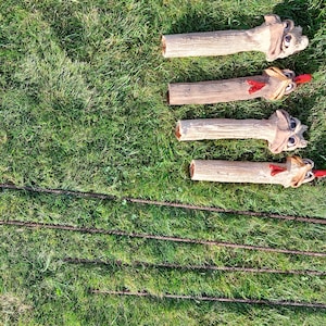Op de afbeelding: Vier keramische kippenfiguren met rode kammen en keelzakken, staand op een groen gazon. De kippen zijn in lichtbruin geverfd en hebben gedetailleerde gezichtskenmerken.
