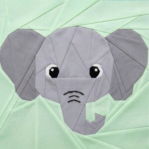 May include: A gray origami-style elephant head with large black and white eyes and a trunk. The elephant is set against a light green background with geometric folds, creating a textured effect. The design is suitable for nursery decor.