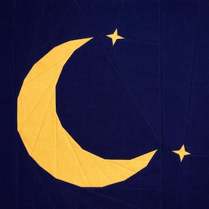 Puede incluir: Una obra de arte textil que presenta una luna creciente amarilla y dos estrellas amarillas sobre un fondo azul oscuro. El diseño está compuesto por formas geométricas, creando un efecto de patchwork. El tema celestial es prominente.