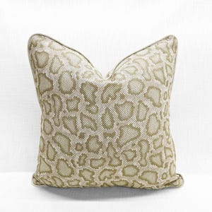 May include: A beige throw pillow with a green snake skin pattern.