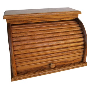 May include: A wooden bread box with a roll-top lid and a small drawer. The box is made of light brown wood and has a natural finish.