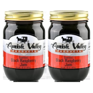 May include: Two glass jars of Amish Valley Products Seedless Black Raspberry Jam, each with a gold lid and a black label with white text. The label features a black and white illustration of a horse-drawn buggy.