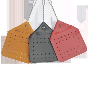 May include: Three fly swatters with leather handles and a perforated surface. The swatters are brown, black, and red.