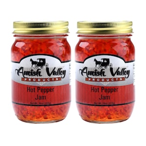 May include: Two glass jars of Amish Valley Products Hot Pepper Jam. Each jar is 18 ounces (510g) and features a red and white label with a black and white illustration of a horse-drawn buggy.
