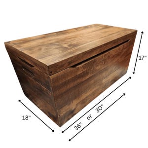 May include: A rectangular wooden storage chest with a hinged lid. The chest is a dark brown color and measures 36 or 30 inches long, 18 inches wide, and 17 inches high.