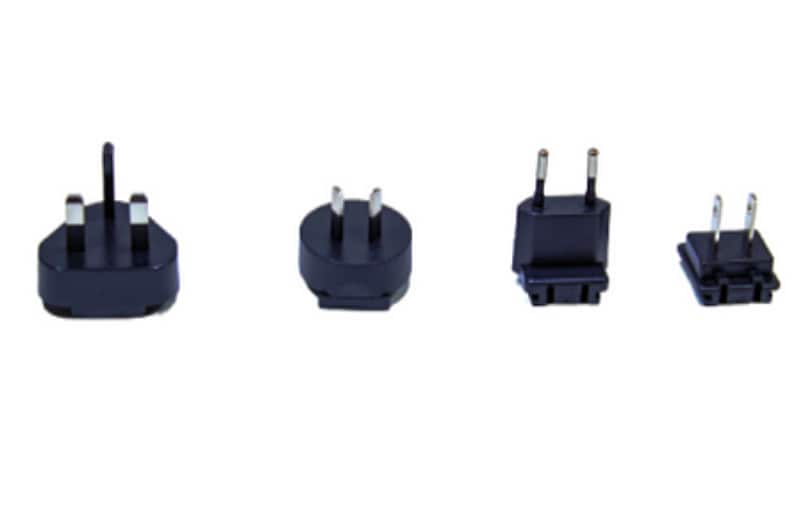 May include: Four black electrical plug adapters with different prongs. The adapters are designed to convert plugs from one country to another.