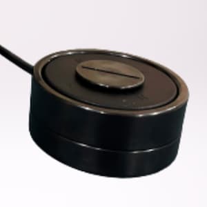 May include: A black round electronic device with a silver screw on top. The device has a black cord attached to it.