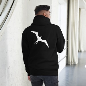 Puede incluir: Sudadera con capucha negra con una silueta blanca de un pájaro en la espalda.