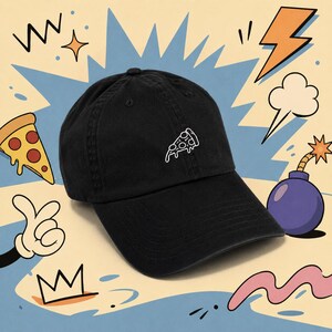 May include: Black baseball cap with a white embroidered pizza slice. The cap is surrounded by cartoon graphics including a pizza slice, lightning bolt, and bomb.
