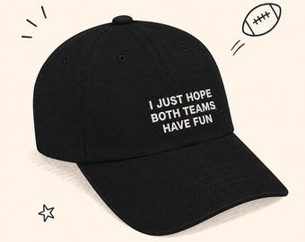 May include: Black baseball cap with the text "I JUST HOPE BOTH TEAMS HAVE FUN" in white. A cartoon football and star are drawn in the background. The cap has a curved brim and a button on top.