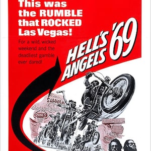 May include: A red and black movie poster for the film "Hell's Angels '69". The poster features a motorcyclist performing a wheelie with a group of other bikers in the background. The text on the poster reads "This was the RUMBLE that ROCKED Las Vegas!" and "Hell's Angels '69".