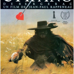 May include: A film poster for the movie "Cyrano de Bergerac" starring Gerard Depardieu. The poster shows a close-up of Depardieu in character, wearing a wide-brimmed hat and a dark cloak, with a sword and a heart in the background.