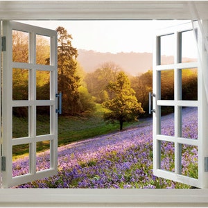 Puede incluir: Una ventana blanca con dos hojas abiertas, que revela una vista de un campo de flores silvestres moradas, una colina verde y un solo árbol en la distancia. El sol brilla intensamente, proyectando un cálido resplandor sobre la escena.